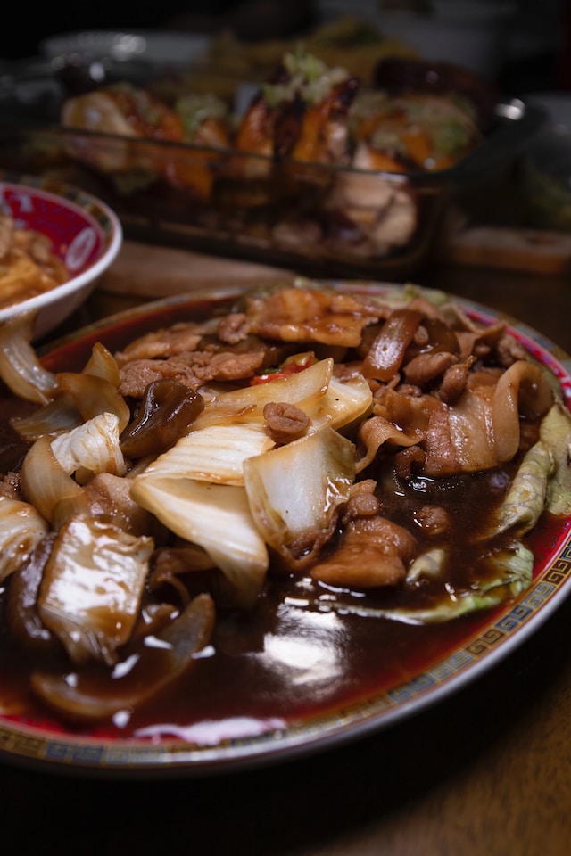 Meat and vegetables in brown sauce served on a ceramic plate