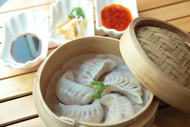 Dimsum inside a bamboo steamer served with different dips
