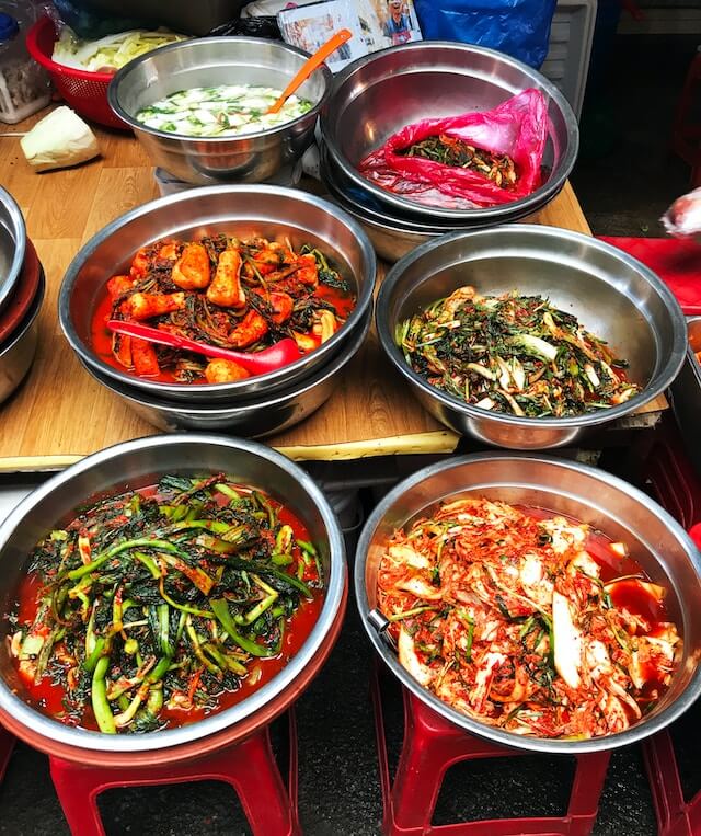 A variety of pickled vegetables in aluminum containers