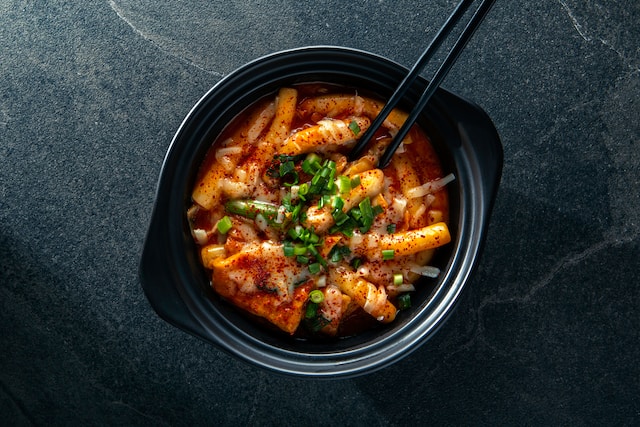 Tteokbokki or spicy rice cakes in a black bowl