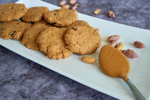 Peanut butter cookies on a ceramic dish with a spoonful of peanut butter on the side