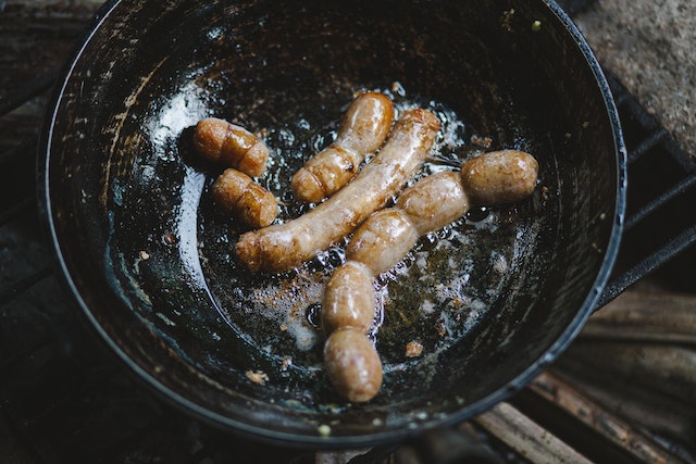 Sausages frying in a pan