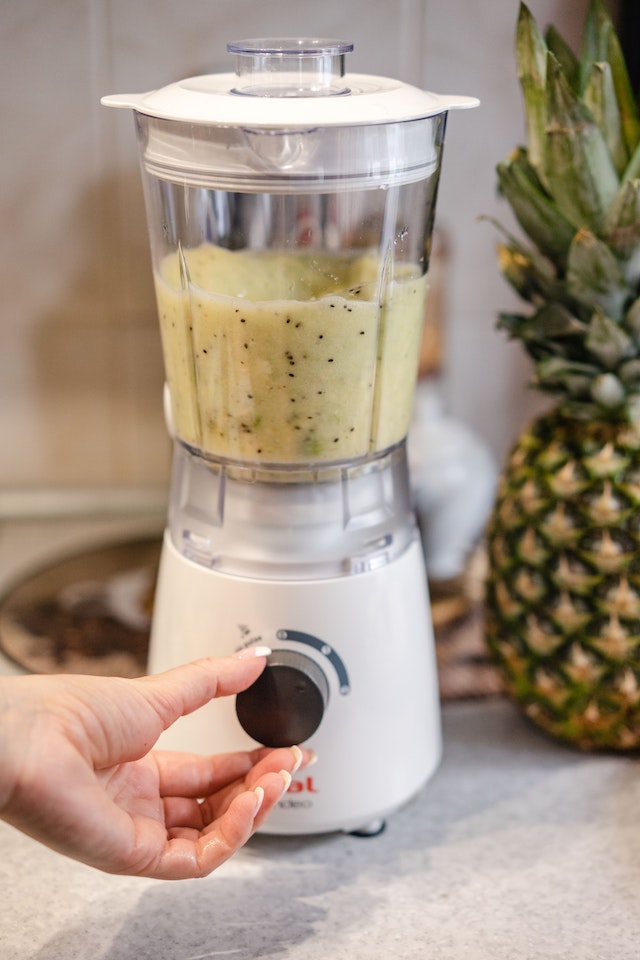 A hand turning the knob on a blender