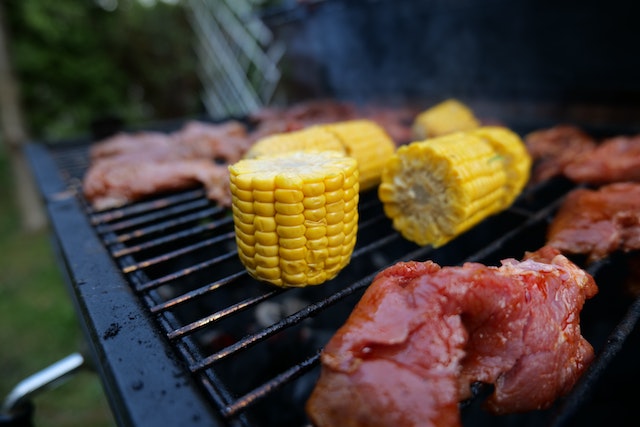 Pieces of meat and corn on a grill