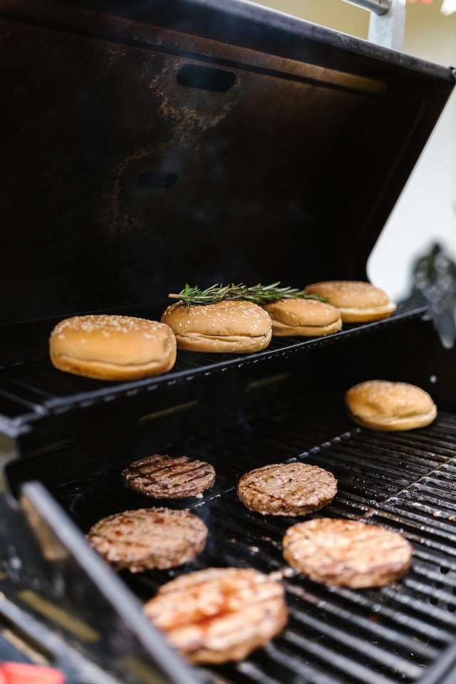 Burgers and buns on a grill
