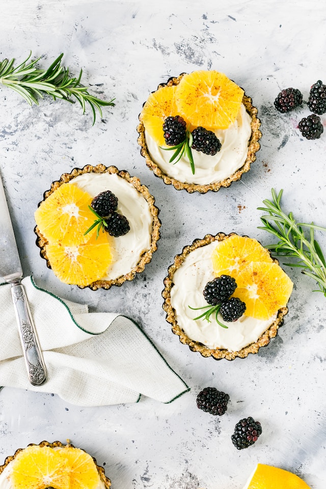 Mini cheesecakes with blackberries and orange slices for toppings