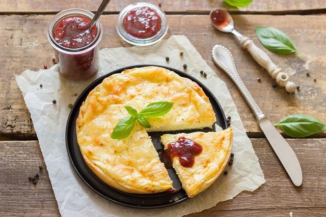 Quiche with tomato sauce dip served on a black plate