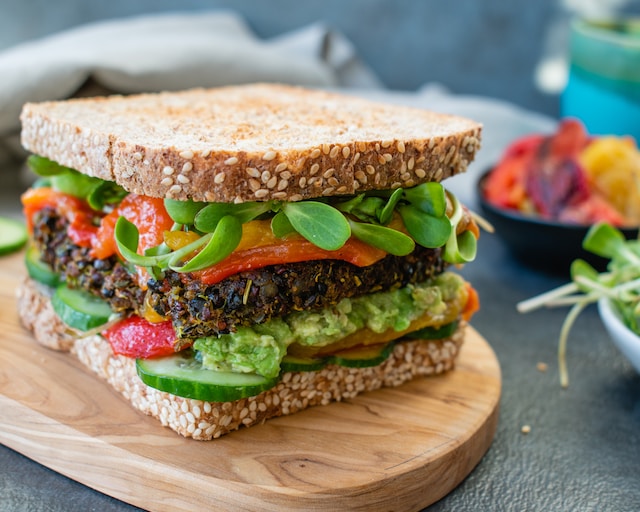 A vegan sandwich featuring assorted vegetables and brown bread