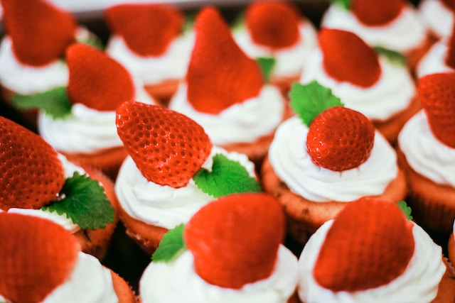 Desserts topped with whipped cream and strawberries