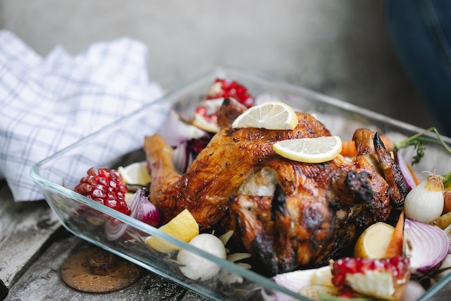 Roasted chicken with assorted vegetables inside a glass baking dish