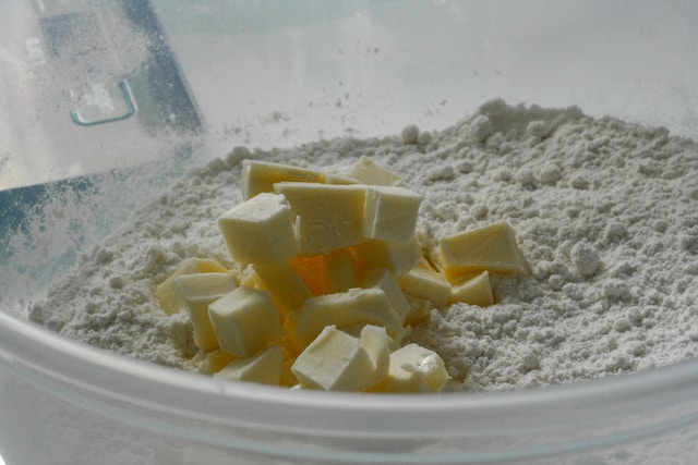 Cubes of butter in a container with flour